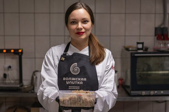 Повар фермы «Волжская улитка» в фартуке с логотипом